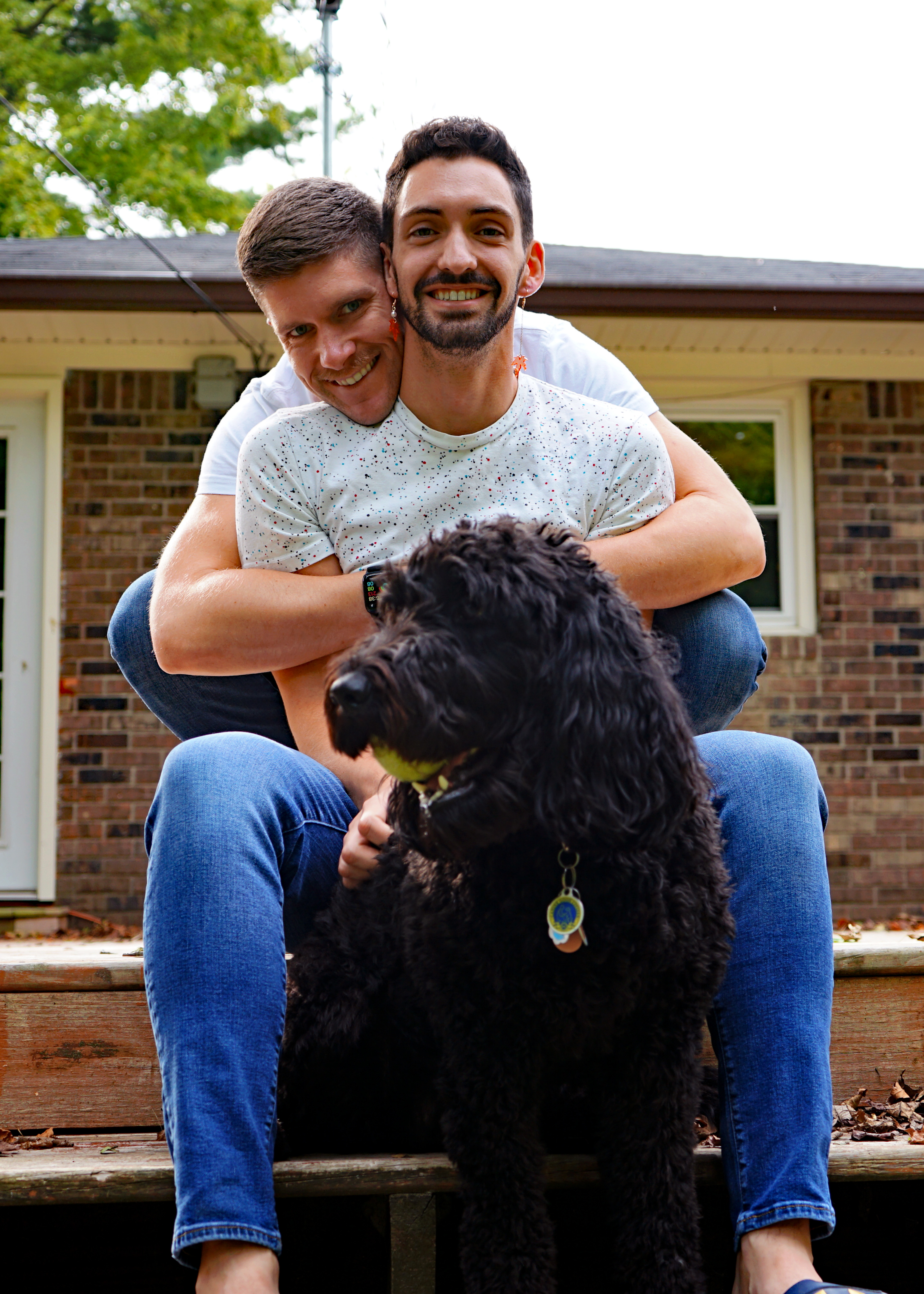 A photo of myself and my fiancé with our dog.